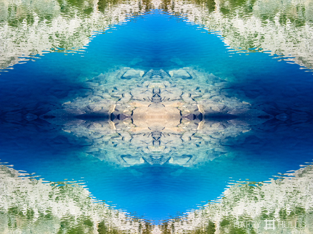 Mountains in the lake. Photo of rocky bottom near the shore of a lake on the Rock Creek Trail, Eastern Sierra Nevada Mountains, California.