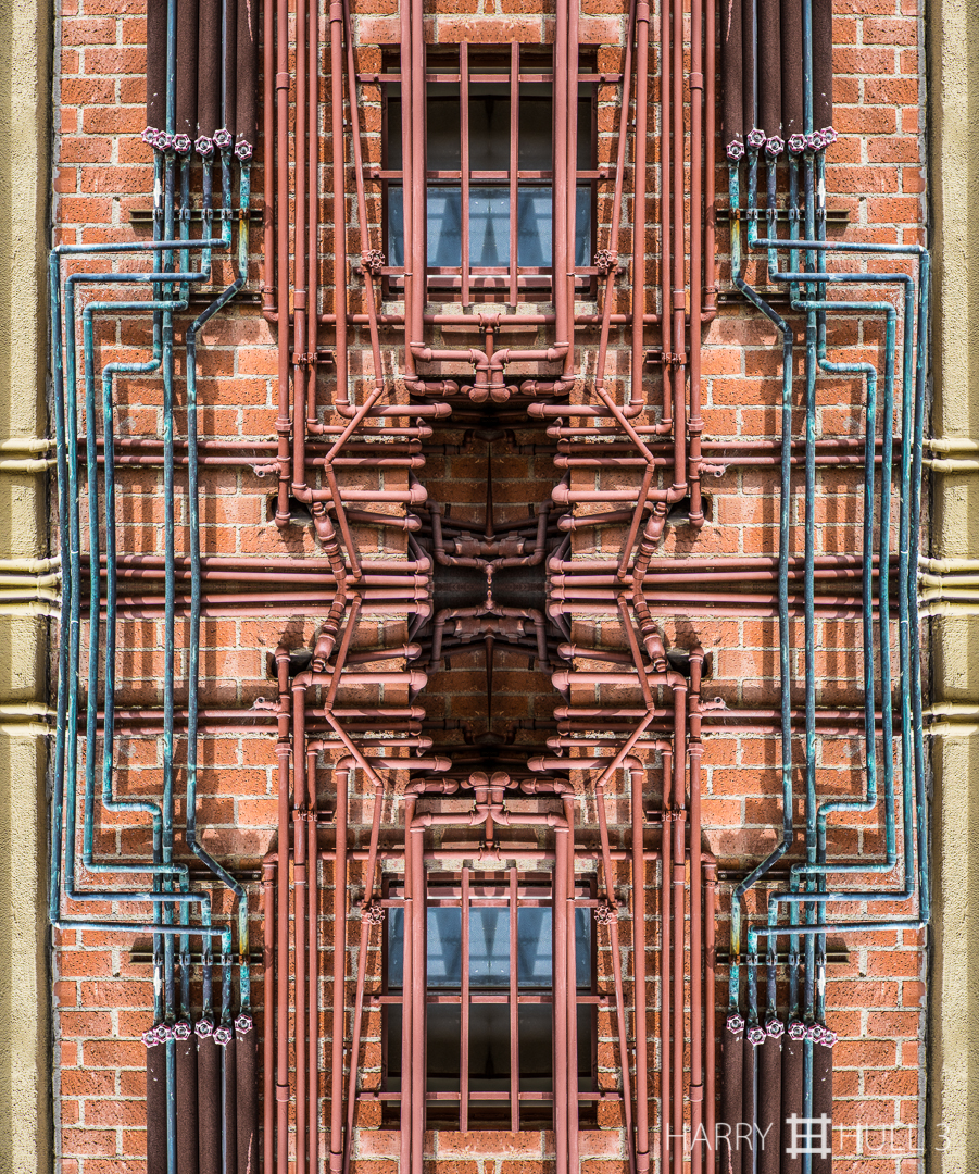 Outdoor plumbing. Photo of piping on the side a building in an alley in Santa Monica, California.