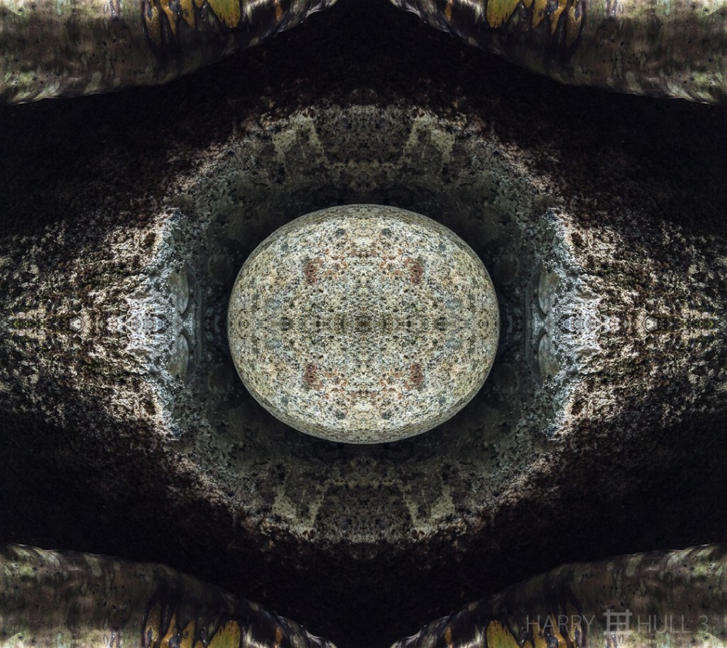 The eye of Ozymandias. Photo of detail of a garden sculpture of a granite rock in a circular opening carved in cement block, with dying banana frond, Finca Cantaros, San Vito, Costa Rica.